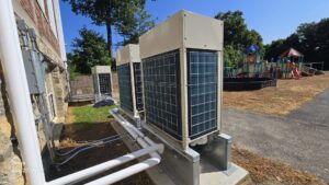 Outdoor HVAC units with visible piping installed next to a building by Clean Air Quality Service Inc in Hawthorne, NY