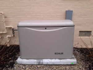 An outdoor Kohler generator and electrical meter installation by Bluegrass Power & Electric in Lexington, KY.