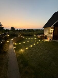 Beautiful outdoor landscape lighting illuminating a yard at dusk by Dr. Sparky in Nashville, TN