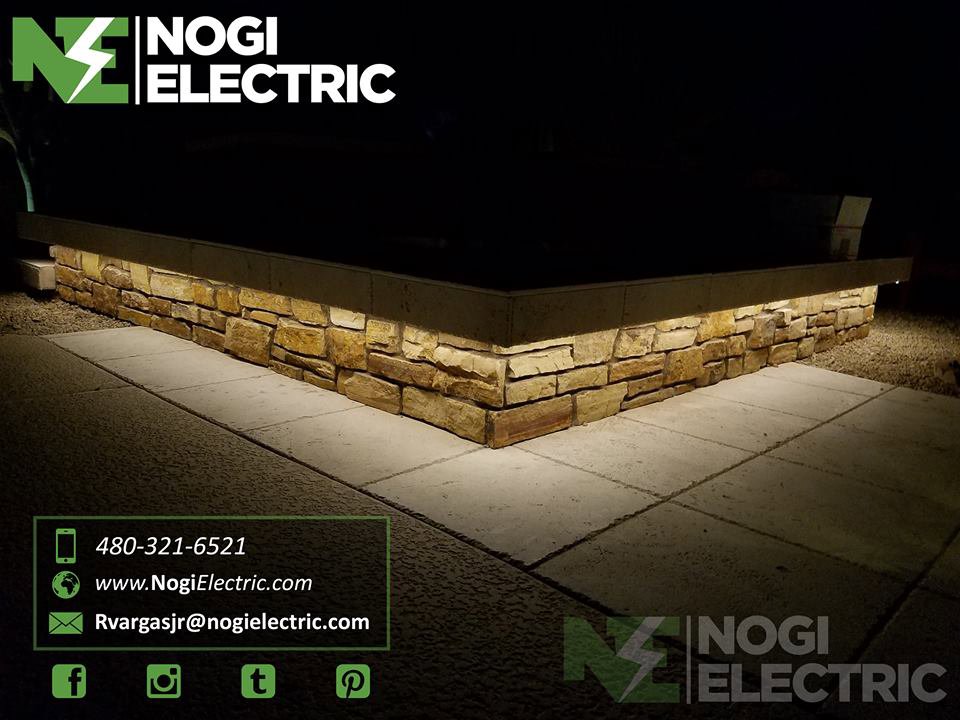 Outdoor landscape lighting installation illuminating a stone planter by Nogi Electric LLC in Mesa, AZ.