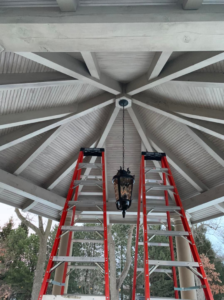 Ladders set up for outdoor lantern installation or repair under a gazebo by Vera Electric in Aurora, IL.