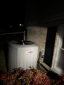 An outdoor Lennox air conditioning unit installed next to a brick house by Adonis Hvac in Annapolis, MD.