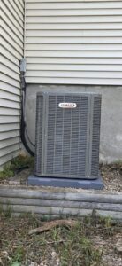 An outdoor Lennox air conditioning unit installed next to a residential building by Preferred Heating & Air in Bismarck, ND.