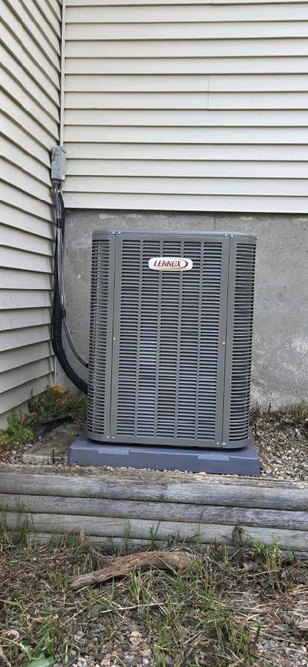 An outdoor Lennox air conditioning unit installed next to a residential building by Preferred Heating & Air in Bismarck, ND.