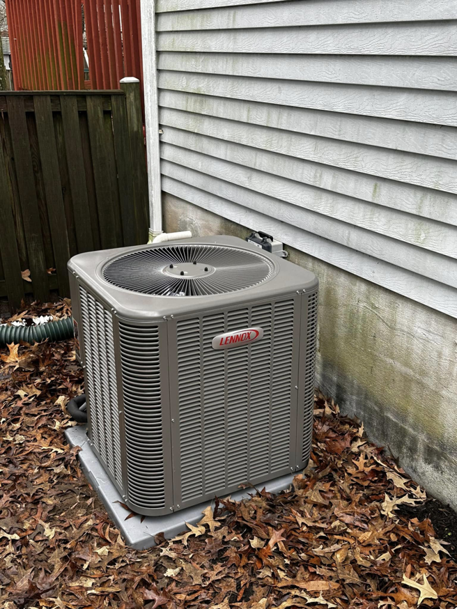 An outdoor Lennox HVAC condenser unit next to a residential building, serviced by Adonis Hvac in Annapolis, MD.