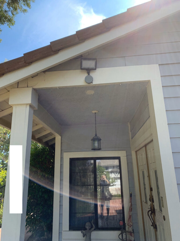 An outdoor light fixture and floodlight installed on a residential porch by Prime Electric in Bellevue, WA.