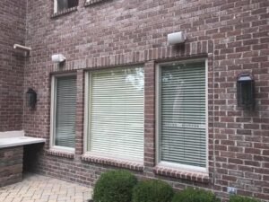 Outdoor wall lanterns and speakers installed on a home exterior by TGR Electric LLC in Carmel, IN.
