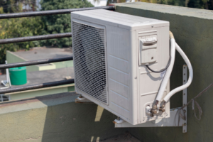 An outdoor mini-split air conditioning unit mounted on a building wall, installed by Custom Heating & Air Conditioning - Nampa in Nampa, ID.