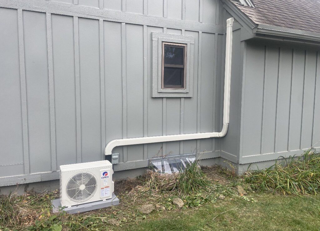 An outdoor mini-split AC unit installation with covered line set by Affordable Heating & Cooling LLC in Olathe, KS.