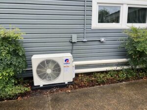 An outdoor mini-split AC unit installed on the side of a residential building by Moreau's Heating & AC in Lake Charles, LA.