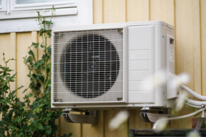 An outdoor mini-split air conditioning unit installed on a residential wall by Terry Allen Plumbing & Heating in Flint, MI.