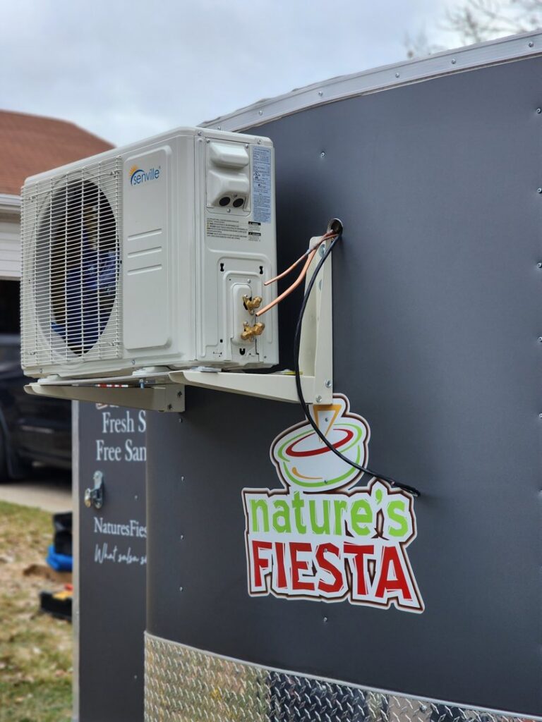An outdoor mini-split AC unit installed on the side of a food trailer by Cutting Edge HVAC LLC in Orem, UT.