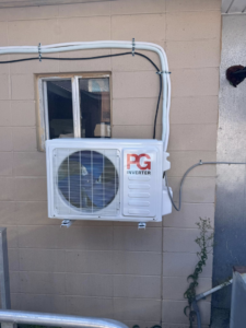 An outdoor mini-split condenser unit installed on a concrete block wall by HD Precision Works in Iota, LA.
