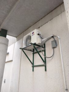 An outdoor mini-split condenser unit installed on a wall bracket by Avery Heating and Cooling in Independence, MO.