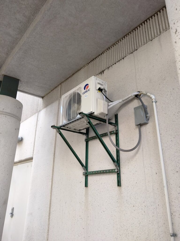 An outdoor mini-split condenser unit installed on a wall bracket by Avery Heating and Cooling in Independence, MO.