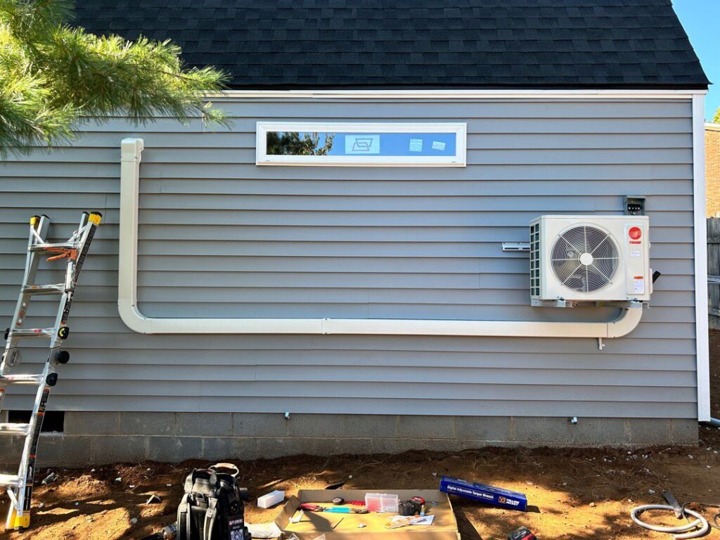 Outdoor mini-split condenser unit installation in progress by Fayette Plumbing & HVAC in Lexington, KY.