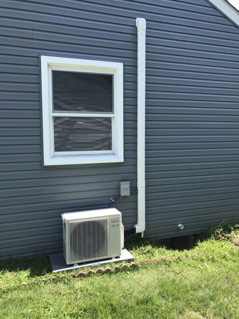 An outdoor Fujitsu mini-split condenser unit installed next to a residential building by Green Air Heating&Cooling in Philadelphia, PA.