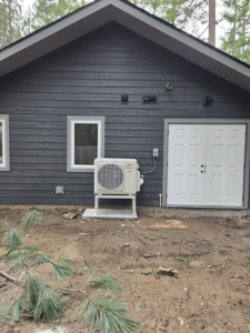 Outdoor mini-split condenser unit installed next to a building by Maddog Contracting LLC in Post Falls, ID.