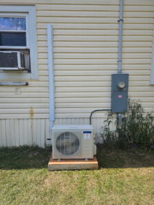 An outdoor mini-split condenser unit installed on the side of a house by Southern Heating & A/C LLC in Mobile, AL.