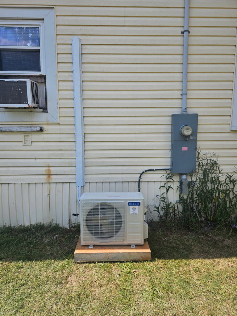 An outdoor mini-split condenser unit installed on the side of a house by Southern Heating & A/C LLC in Mobile, AL.