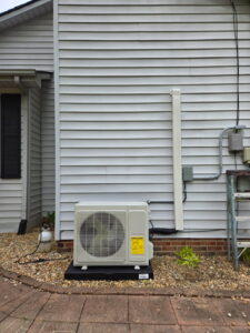 An outdoor mini-split condenser unit installed next to a residential home by Aces of Air Inc. in Georgetown, KY.