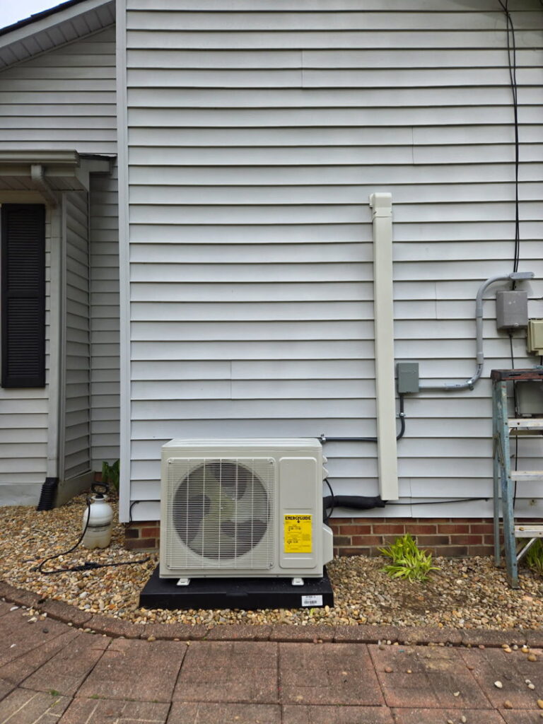 An outdoor mini-split condenser unit installed next to a residential home by Aces of Air Inc. in Georgetown, KY.