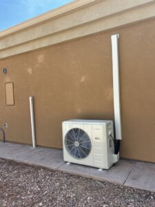 An outdoor mini-split condenser unit with line set cover installed by Buddy's Refrigeration LLC in Mesquite, NV.