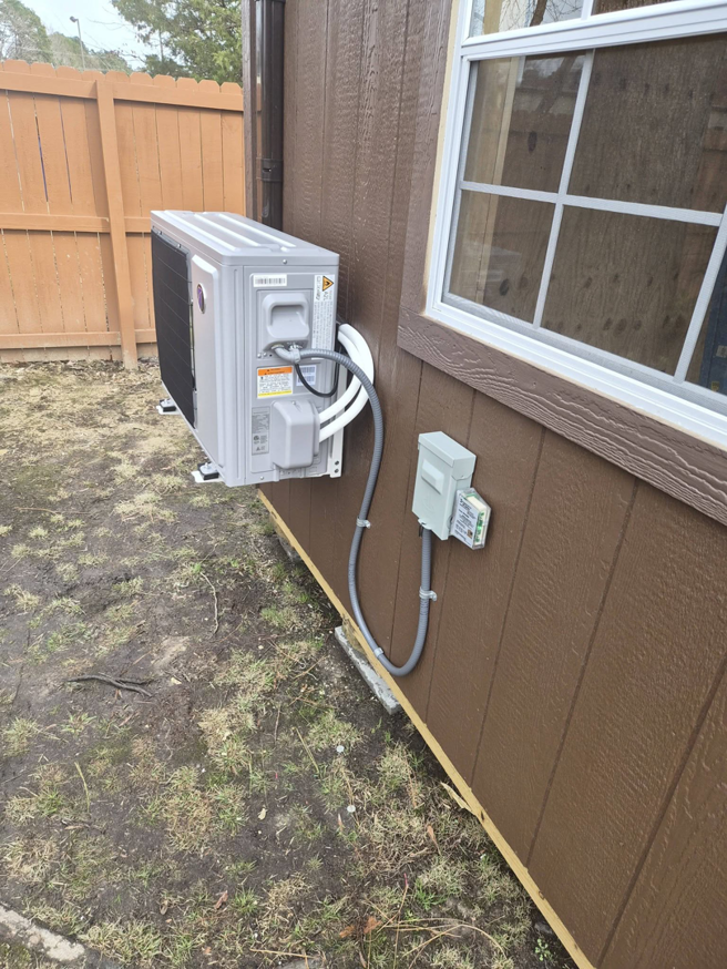 An outdoor mini-split condenser unit with electrical and refrigerant lines installed by Jesse's HVAC LLC in Newport News, VA.