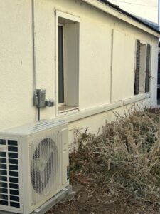 An outdoor mini-split condenser unit installed next to a building by R&R Mechanical Services in Greeley, CO.