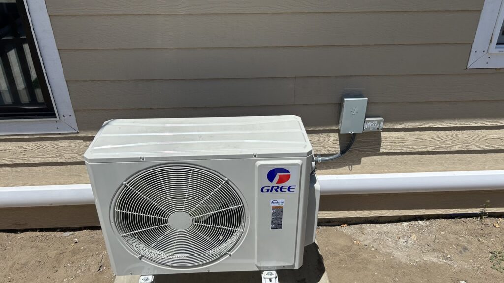 An outdoor mini-split HVAC condenser unit installed next to a residential building by Service Kings Heating and Air in Jamestown, ND.