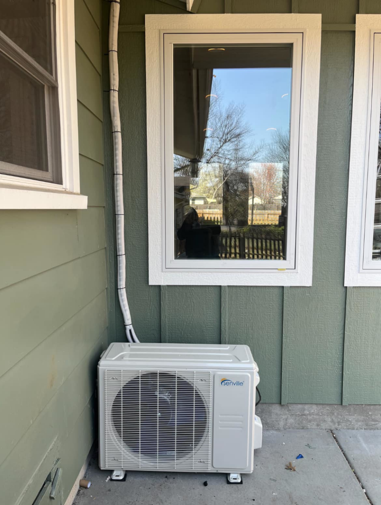 An outdoor mini-split HVAC unit installed next to a building by Emerald Air in Wichita, KS.