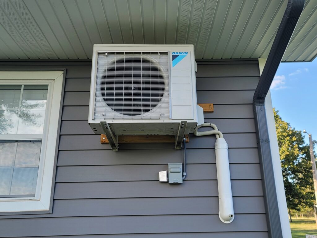 An outdoor mini-split HVAC unit professionally installed on the side of a residential home by Fusion Heat and Air in Fort Smith, AR.
