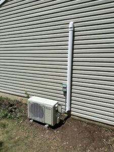 An outdoor mini-split unit installed next to a house by P3 Mechanical Heating & Cooling in Bainbridge, PA.