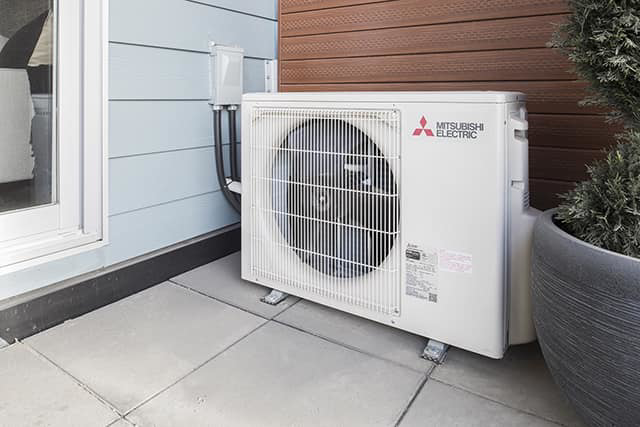 An outdoor Mitsubishi Electric HVAC condenser unit installed by Forever Mechanical INC. in Worcester, MA