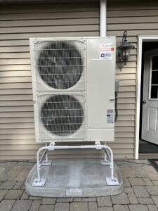 An outdoor Mitsubishi Electric Smart Multi HVAC unit installed next to a residential building by Simply Installs Heating & Air Conditioning in Shortsville, NY.