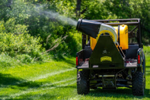 An outdoor mosquito treatment being applied by a utility vehicle from Fog'em Mosquito Control in a green area in Bismarck, ND.