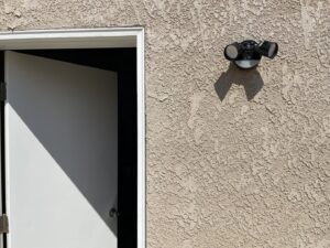An outdoor motion sensor light fixture installed next to a door by Electrical Power Source in Fresno, CA.