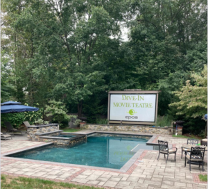 An outdoor movie theatre screen installed by EPOS Systems, Inc. in West Springfield, MA, featuring their logo.