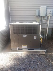 An outdoor package HVAC unit installed on a concrete pad next to a house by TAG Heat N Air in North Little Rock, AR.