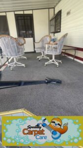 A professional cleaning an outdoor patio carpet with a cleaning wand by Specialty Carpet Care in Surprise, AZ