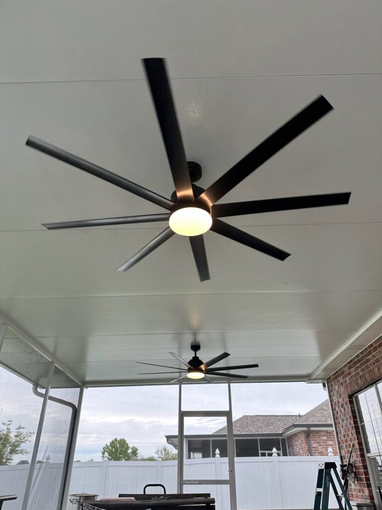 Two large ceiling fans with lights installed on an outdoor patio by LiveWire Electrical Services, LLC. in Houma, LA.
