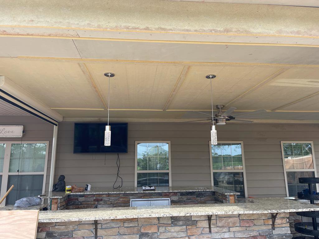 Outdoor patio with installed pendant lights, ceiling fan, and TV, completed by J&M Electrical Services in Stockbridge, GA.