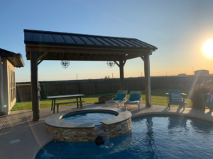 Outdoor patio with a pool and pergola featuring installed lighting by Chuck's Electric and Construction in Corpus Christi, TX