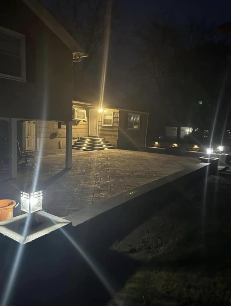 Bright outdoor patio lighting installed by TD Electric in Waterbury, CT, illuminating a backyard space at night.