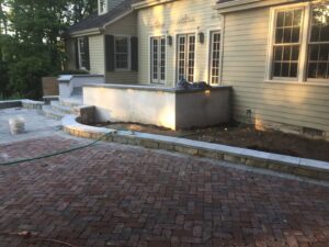 Exterior view of a house with new patio and retaining wall lighting installed by Abe Electric LLC in Wallingford, CT.