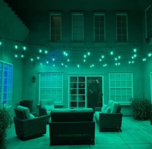 Outdoor patio string lights installed and glowing green by GET LIT Electrical Services LLC in Glendale, AZ.