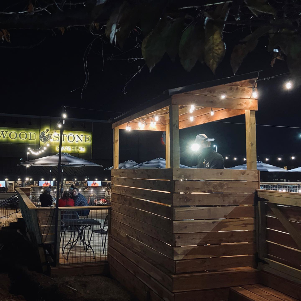 Outdoor patio with string lights installed by Natural State Electric LLC, illuminating a restaurant area in Fayetteville, AR.