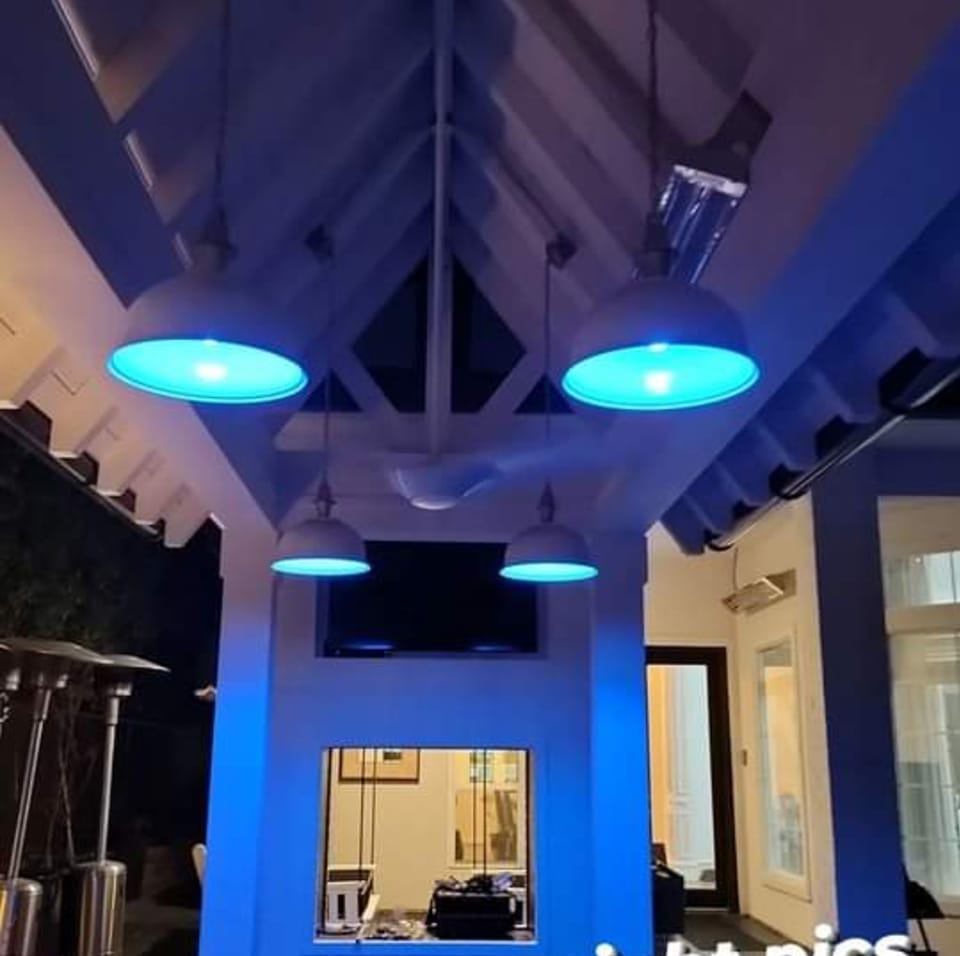 Outdoor pendant lighting installation with a blue glow by Kross Homes & Security in Dallas, TX