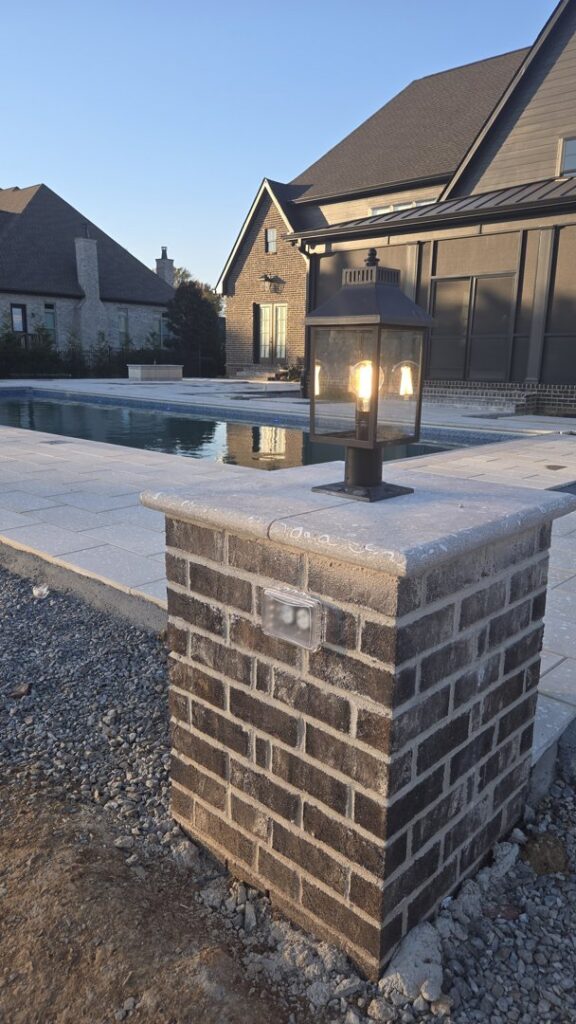 An outdoor light fixture installed next to a pool, showcasing exterior lighting work by Grounded Electric LLC in Smithfield, VA.