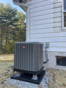 An outdoor Rheem air conditioning unit installation next to a residential building by Force Mechanical Services in Churchville, MD.